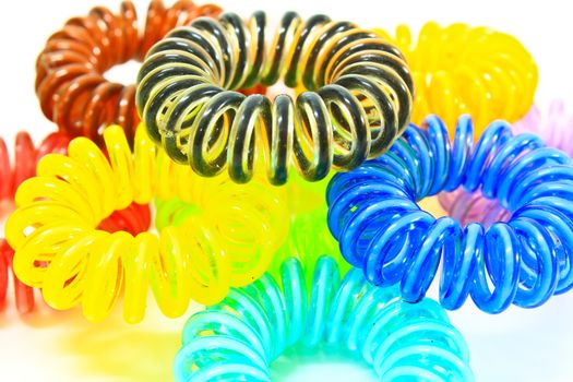 Spiral colorful elastic hair ties used on a white background.