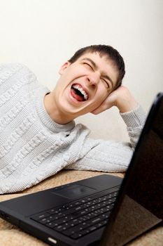 Teenager hysterical laughing with Laptop on the Sofa