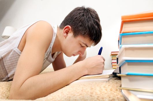 Side view of the Teenager doing Homework at the Home