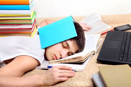 Tired Teenager sleeping on the Sofa with the Books