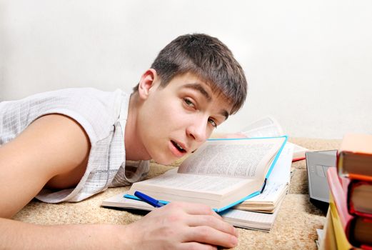 Sleepy Teenager awake on the Sofa with the Books