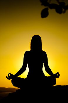 Young model is doing yoga on seaside at sunrise