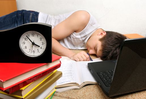 Teenager sleeping after prepare for Exam at the Home. Focus on the Clock