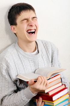 Teenager reads a Books and Laughing on the Sofa at the Home