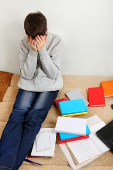 Sad Teenager on the Sofa with the Books at the Home