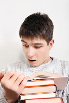 Surprised Teenager reads a Book at the Home