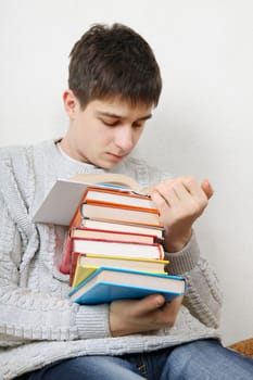 Teenager reads a Books on the Sofa at the Home