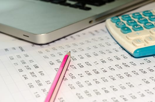 Accounting documents and a calculator placed at the table.