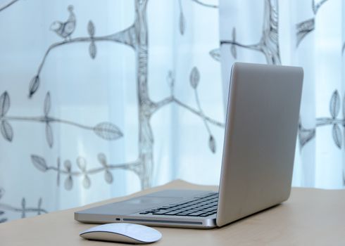 Notebook computer with the mouse and placed on the desks.