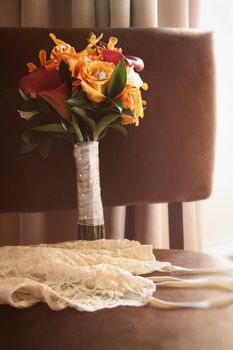 Wedding ring and lingerie with bouquet on chair