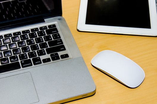 Notebook computer with the mouse and placed on the desks.