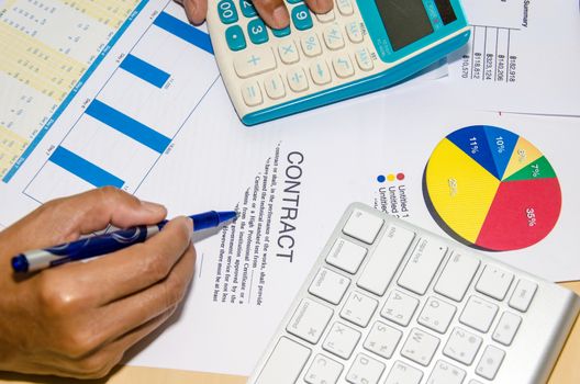 The contract documents and calculator at desk.