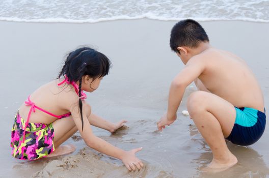 Girl playing in sand at the beach.