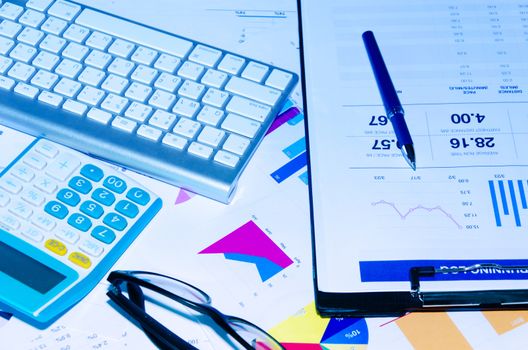 Clipboard and graph and calculator at desk.