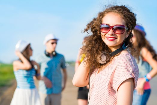 young woman with headphones on a background of blue sky and funny friends