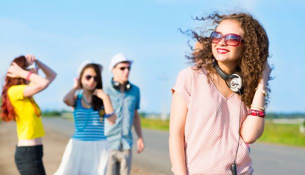 young woman with headphones on a background of blue sky and funny friends