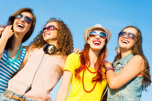 group of young people wearing sunglasses and hats hugging and standing in a row, spending time with friends