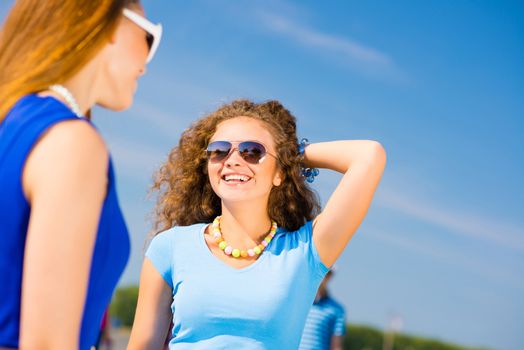 portrait of a stylish young woman on the background of young merry friends, spending time with friends