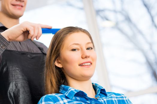 male hairdresser puts woman's hair in a hairdressing salon