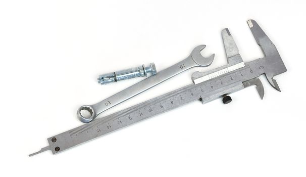 Slide caliper, spanner and anchor bolt. Isolated on white background