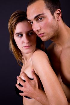 young couple together portrait on black background