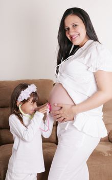 girl examining pregnant mother's tummy