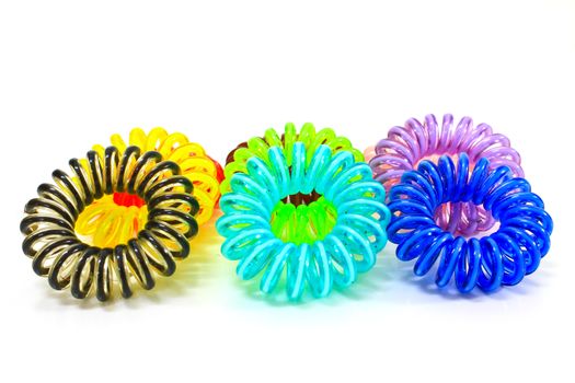 Spiral colorful elastic hair ties used on a white background.