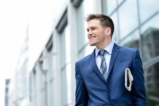 Young businessman holding a newspaper at outdoors