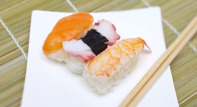 Sushi nigiri in with dish with bamboo sticks