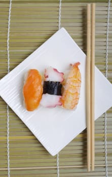 Sushi nigiri in with dish with bamboo sticks 