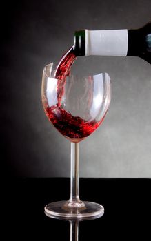 Pouring red vine into a broken glass