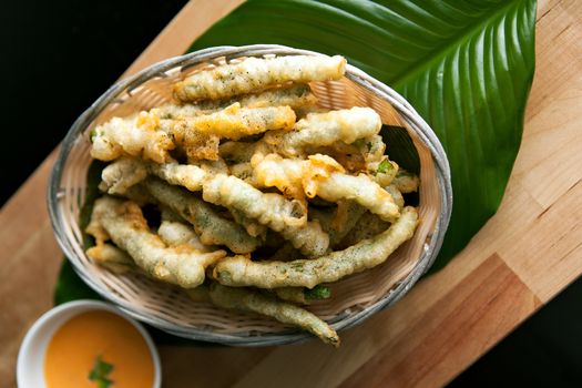 Thai style appetizer of fried tempura asparagus with dipping sauce. 