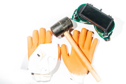 Hammer, gloves, goggles and a dust mask. Construction on white background Construction on white background