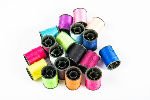 Colorful sewing threads on white.