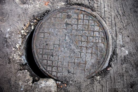 Open old manhole with metal cover.