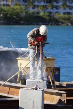 Man working with jackhammer in a harbor