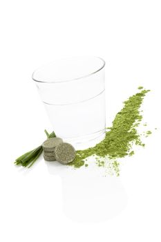 Spirulina; chlorella and wheatgrass. Green food supplement. Green effervescent pills; wheatgrass blades and ground powder isolated on white background. Healthy lifestyle.