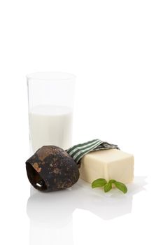 Traditional dairy still life with mil and butter with fresh basil and cowbell isolated on white background. Traditional organic dairy still life with copy space.