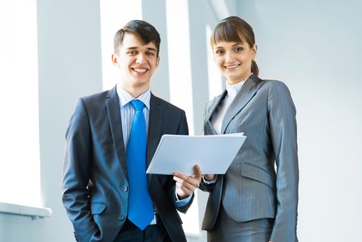 two business partners discussing documents in a bright office