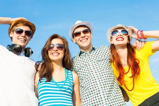 group of young people wearing sunglasses and hats hugging and standing in a row, spending time with friends