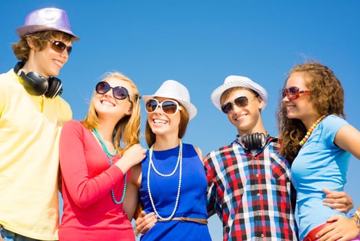 group of young people wearing sunglasses and hats hugging and standing in a row, spending time with friends