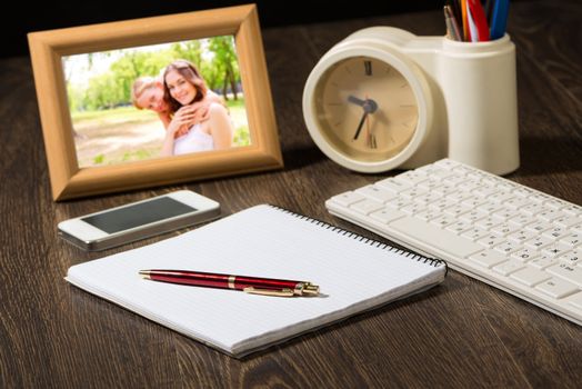 photo frame, mobile phone and notebook with a ballpoint pen. Workplace of the businessman.