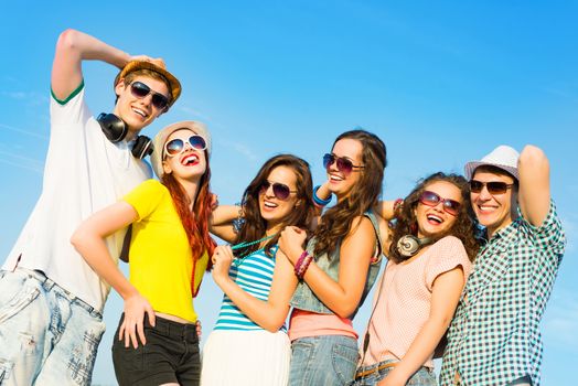 group of young people wearing sunglasses and hats hugging and standing in a row, spending time with friends