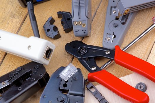 Arrangement of Computer Network Tools for Crimping, Cutting and Connecting closeup on Wooden background