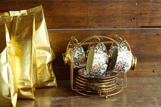 white ceramic tea set with gold rim on wood table,shallow focus