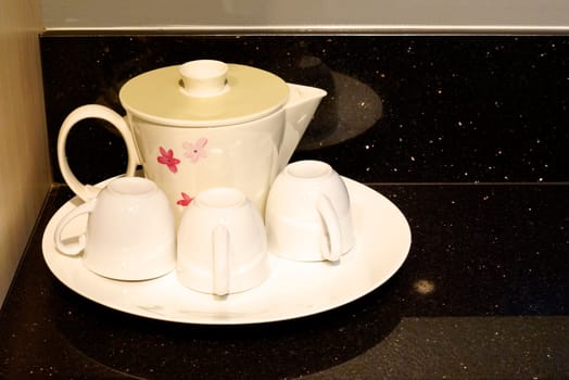 white ceramic tea set on black marble table,shallow focus