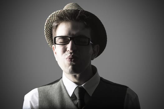 Funny portrait of young stylish man against grey background