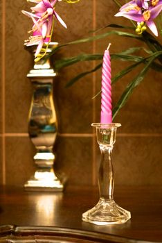 glass candle stick and violet candle on wood deck