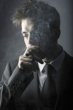 Young stylish man smoking a cigar