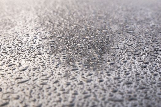 Water drops on metal background with reflection blurred on the edges
